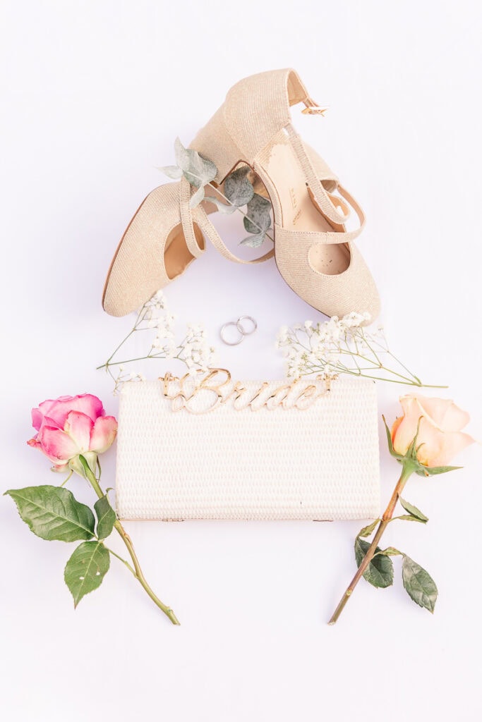 Brautschuhe und Tasche mit Rosen und Ringen