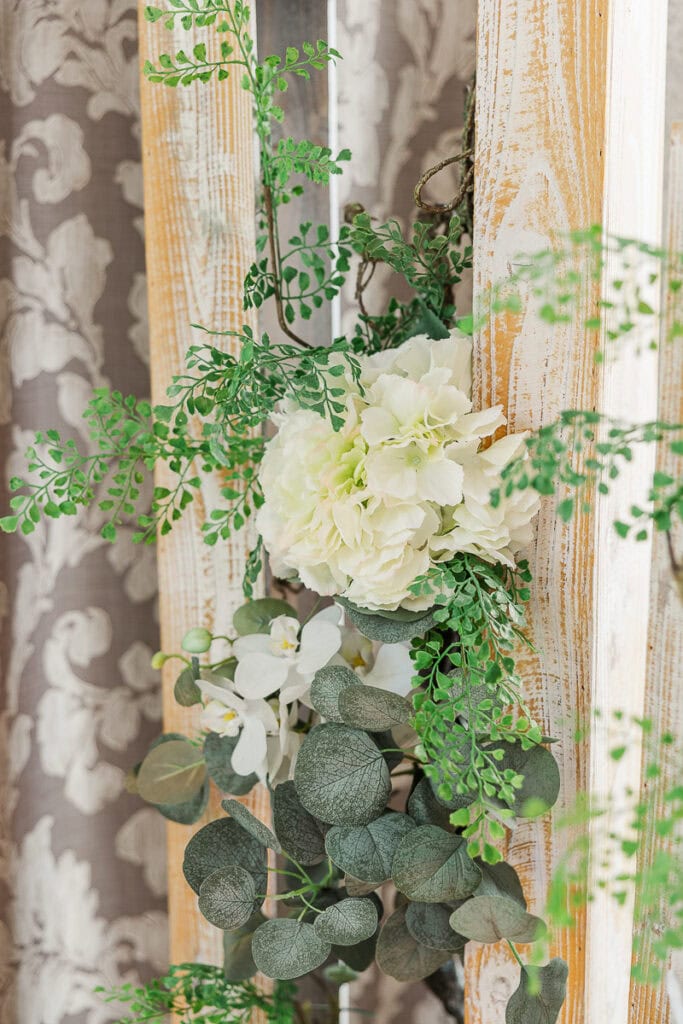 Blumenarrangement mit grünen Blättern und Holzdekoration