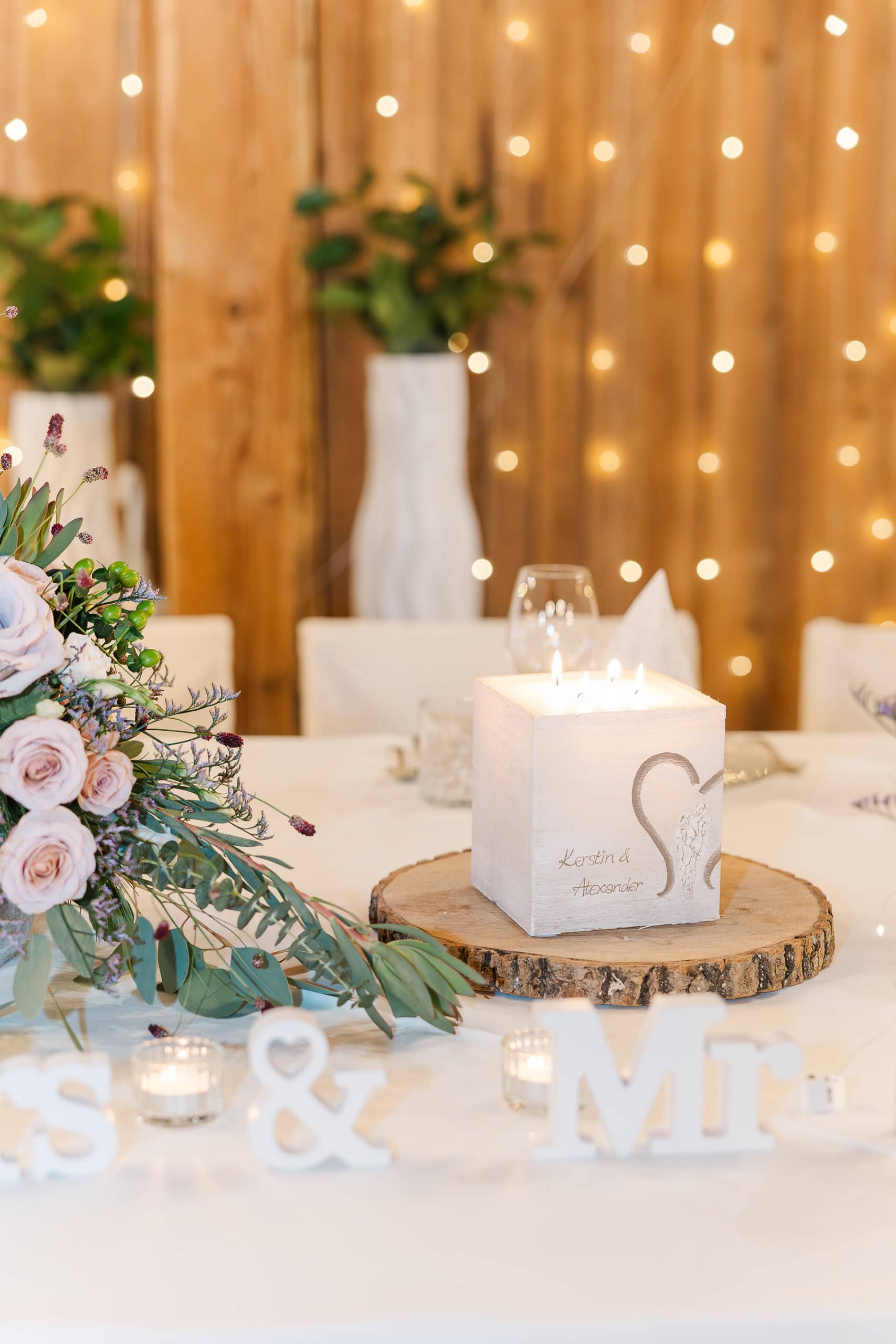 Hochzeit Stadlerhof – Hochzeitskerze am festlich dekorierten Brauttisch