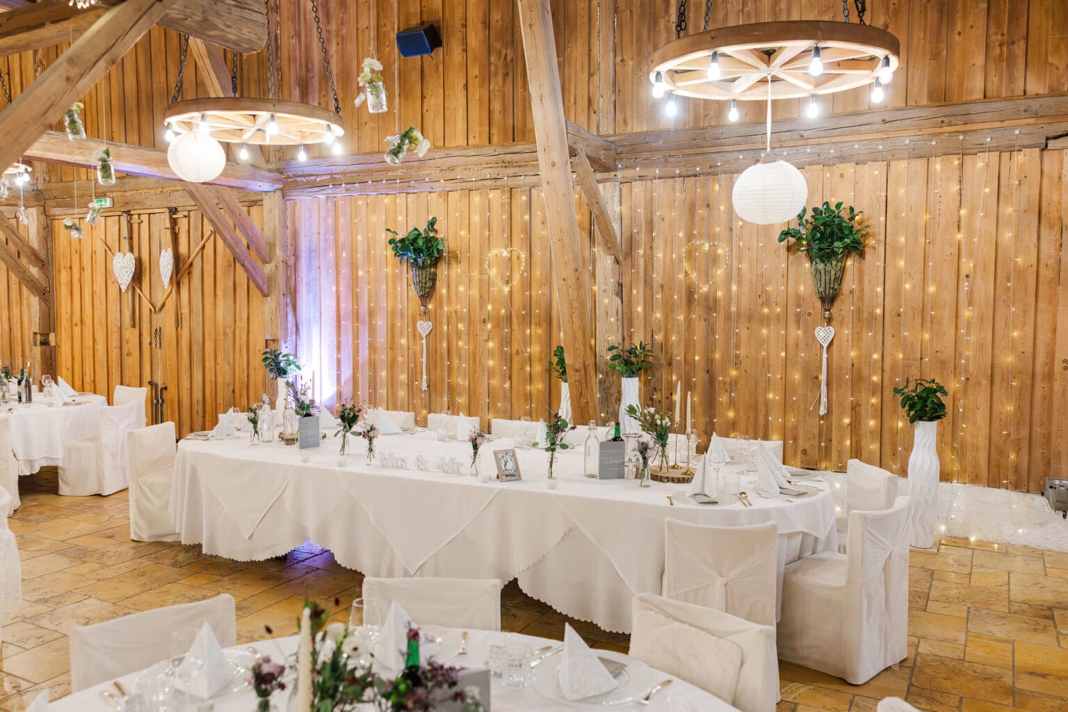 Hochzeit Stadlerhof – Brauttisch im Feststadel mit Blumendekoration